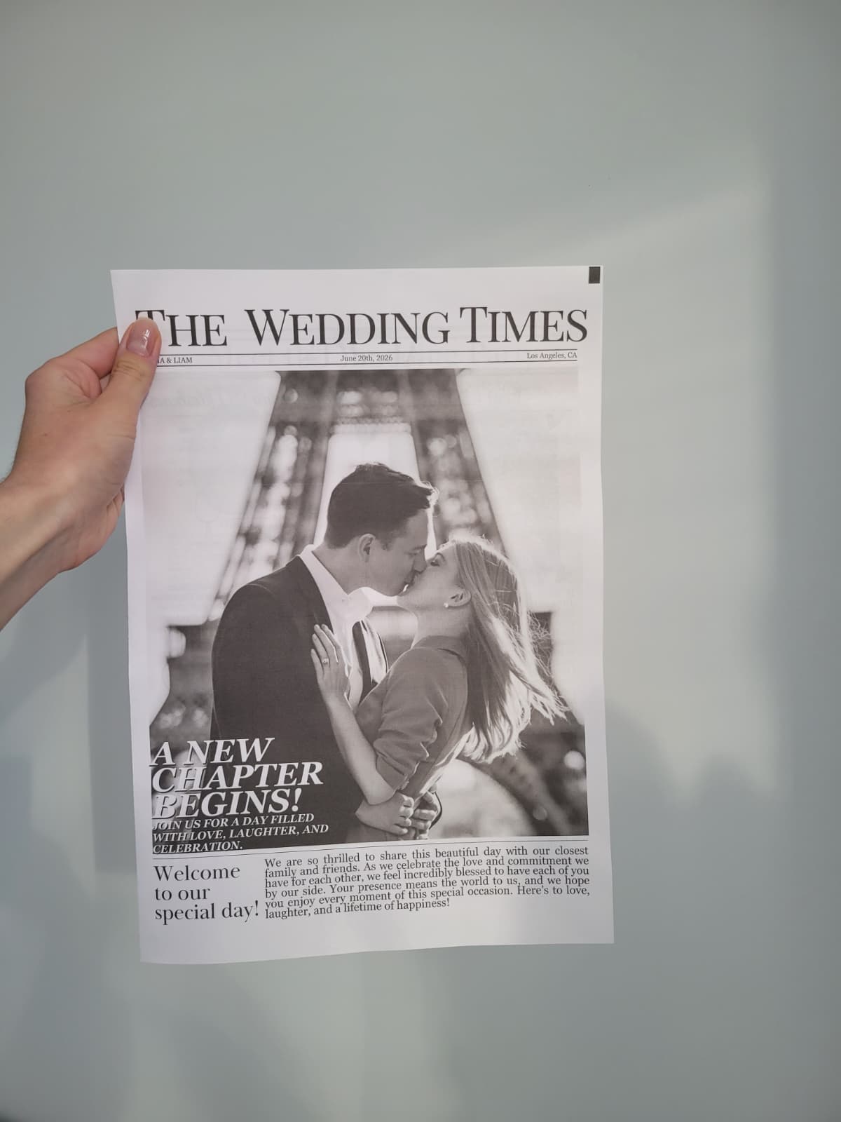 Elovaine wedding newspaper held against wall